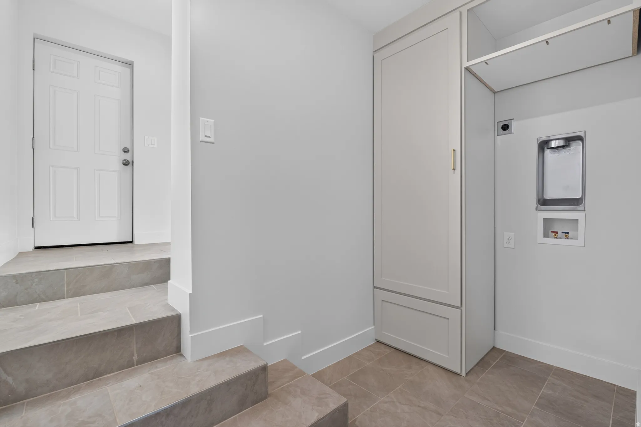 Built-in cabinetry, tile flooring, and light wall finishes