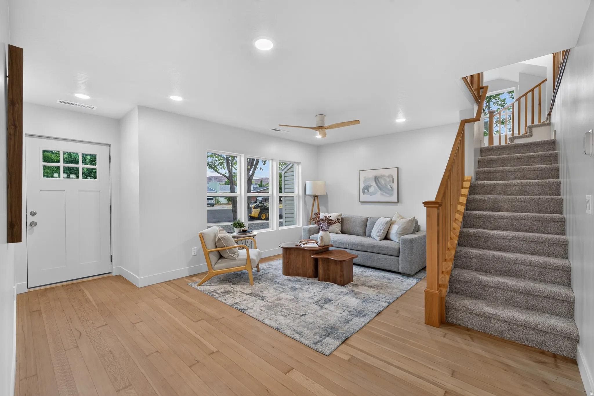 Open-concept living area featuring light wood-finish flooring, recessed lighting, and a contemporary ceiling fan