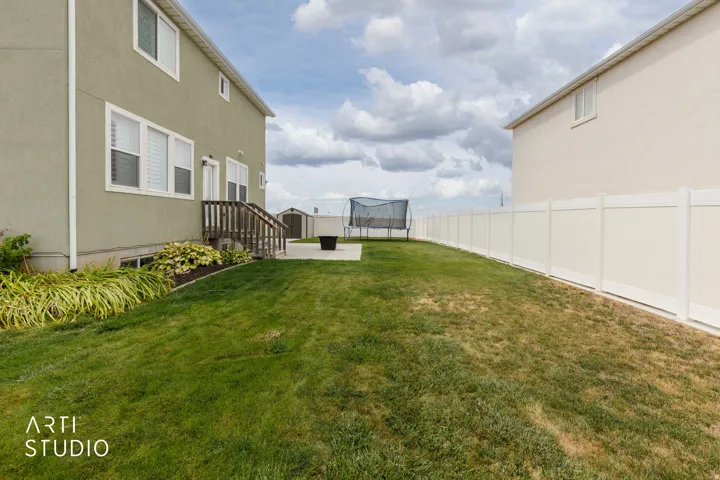Expansive green lawn with a white privacy fence