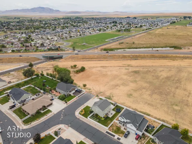 Expansive residential area with a prominent highway system, a large undeveloped land parcel, and distant mountain ranges