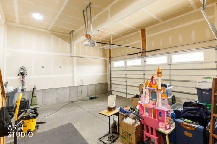 Attached garage with an overhead door featuring transom windows and an automatic opener