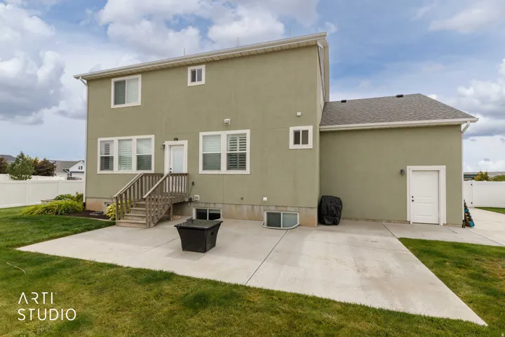 Expansive rear patio with concrete surfacing and direct access to the interior