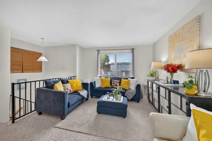 Wall-to-wall carpeting, window with horizontal blinds, built-in wooden shutters, and a suspended ceiling light fixture