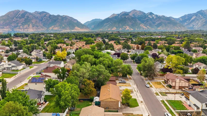 Residential neighborhood with established street infrastructure and mature trees, set against a prominent mountain range