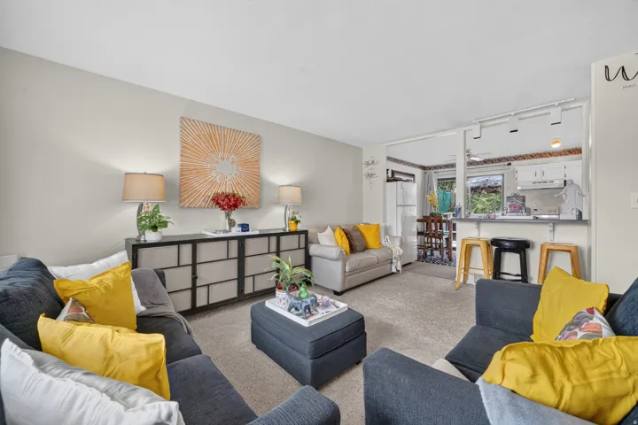 Expansive living area with neutral carpeting and light wall tones