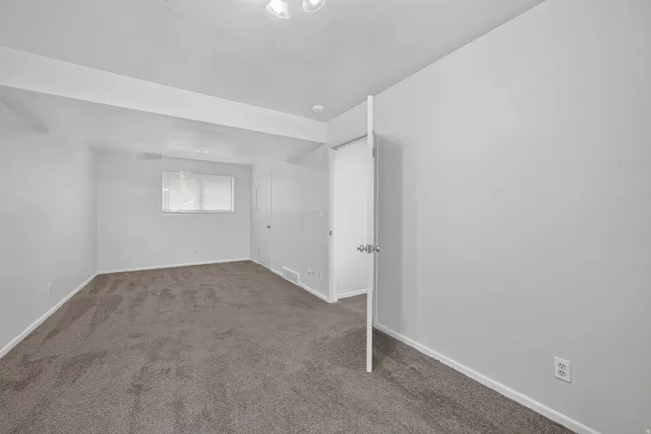 Neutral-toned carpet flooring and white painted walls create a versatile interior
