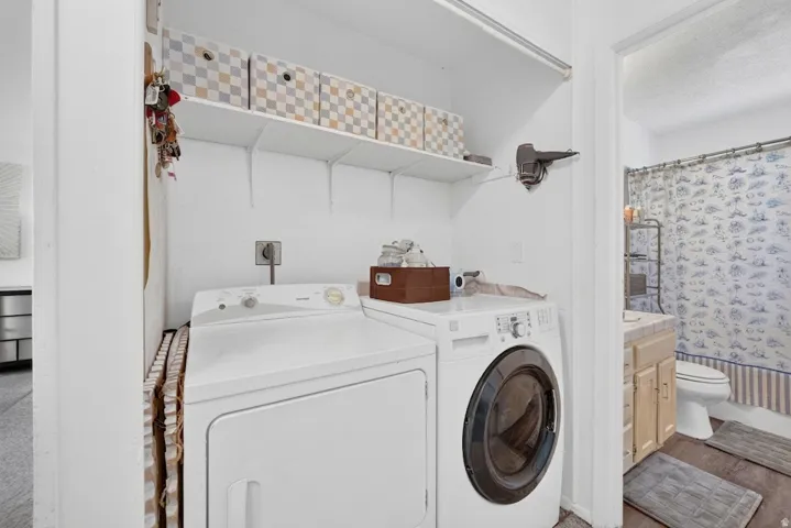 Laundry area featuring upper shelving and a front-load washing machine