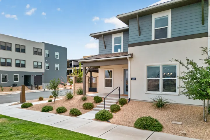 Modern exterior featuring mixed siding, a covered entry, and a minimalist xeriscape