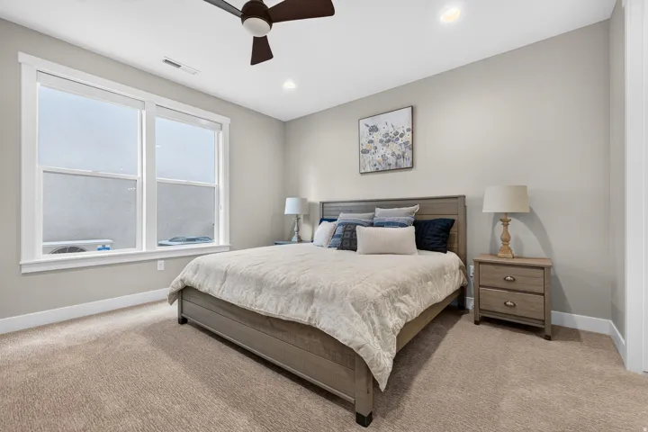 Recessed lighting, ceiling fan, expansive window, neutral wall tones, and carpeted flooring