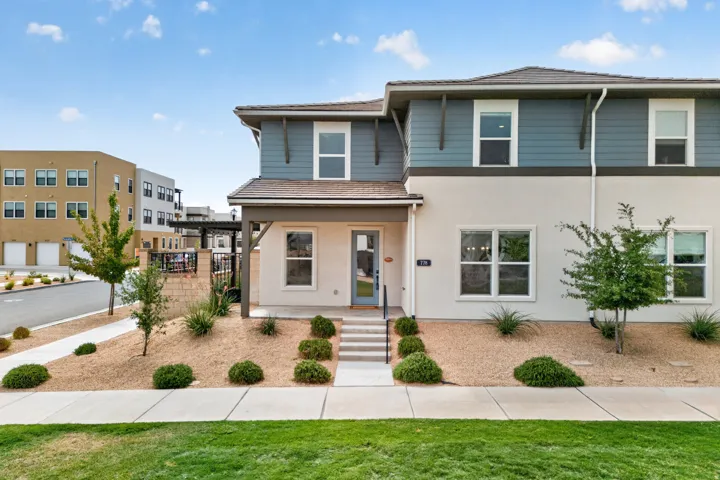 Contemporary exterior with mixed material facade, covered entry, and front yard landscaping