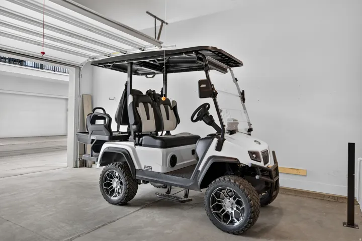 Garage space with a concrete floor, white walls, and an overhead door