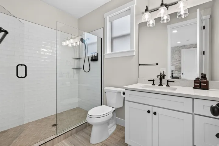Spacious walk-in shower with a glass enclosure, subway tile surround, and chevron-patterned shower floor