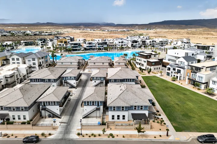 Expansive community featuring a large, blue-water lagoon, multiple multi-story residences, and dedicated green spaces
