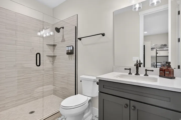 Frameless glass shower enclosure with a rainfall showerhead and built-in shelving