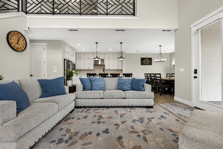 Two-story living area with decorative metal balcony railing, open concept layout, and recessed lighting