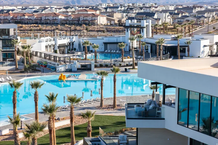 Expansive azure lagoon, mature palm trees, contemporary architecture, glass-paneled balcony, surrounding residential development