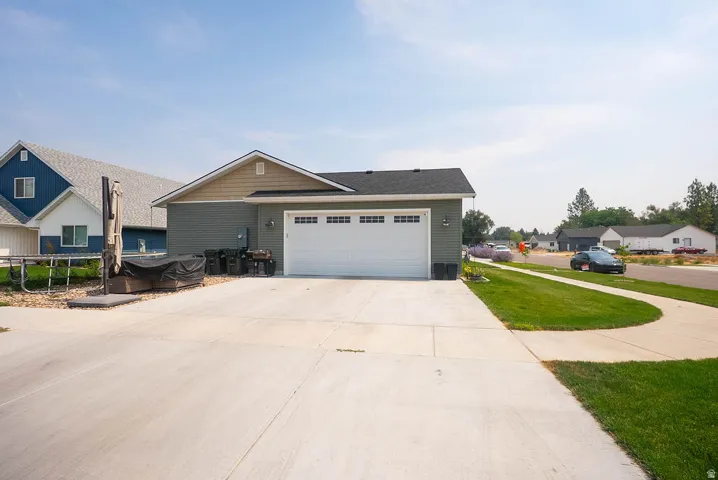 Single-story residence featuring horizontal siding, a gabled roof, and an attached two-car garage with a white overhead door