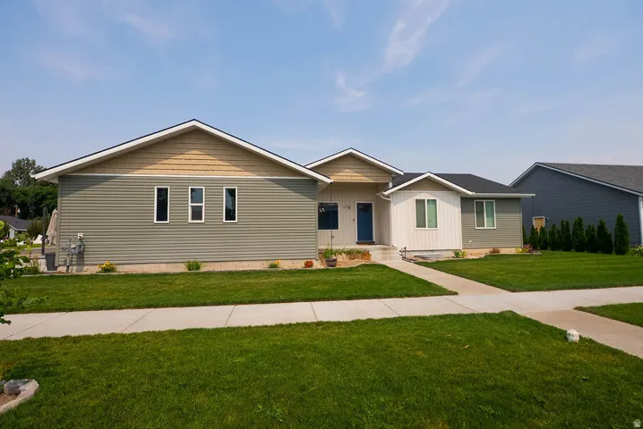 Contemporary exterior featuring multi-toned siding, a deep blue entry door, and a concrete walkway