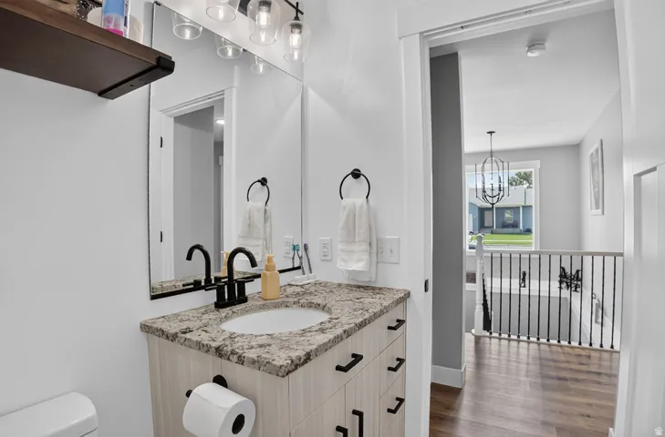 Vanity with a polished stone countertop, undermount sink, and matte black fixtures
