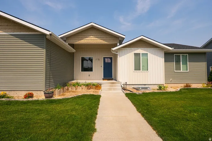 Contemporary exterior with mixed siding, a dark blue entry door, and a concrete pathway