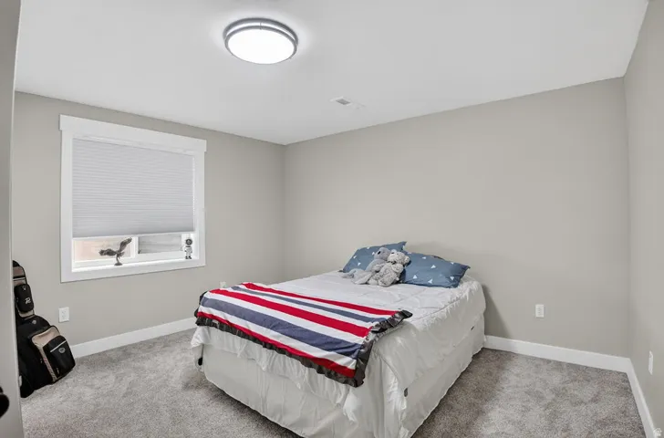Recessed window with white trim, cellular shade, light gray walls, gray carpeting, and a flush-mount ceiling light