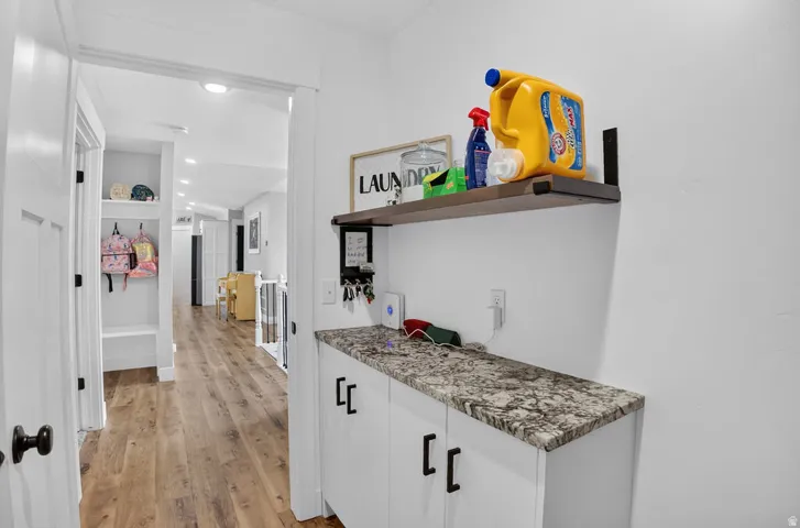 Built-in cabinetry with dark hardware and a stone-finish countertop
