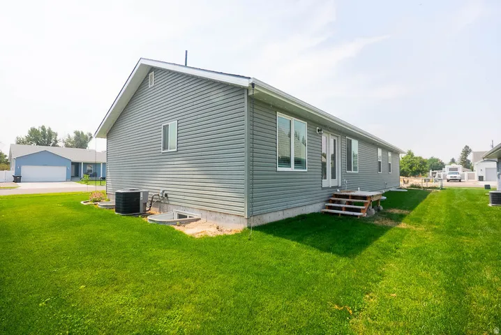 Exterior featuring horizontal siding, white trim, multiple windows, and an outdoor unit