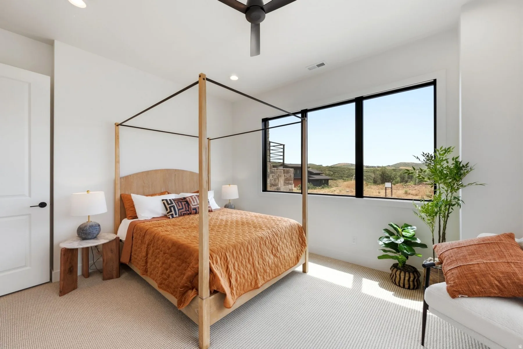 Recessed lighting, ceiling fan, expansive window, neutral carpet, and white interior door with black hardware