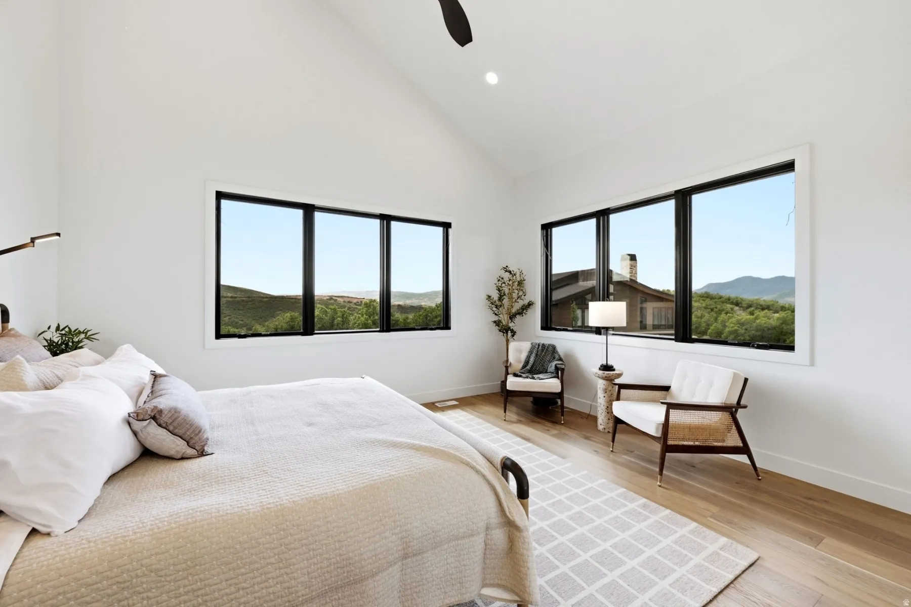 Vaulted ceiling, recessed lighting, wood-finish flooring, black-framed windows, built-in light fixture