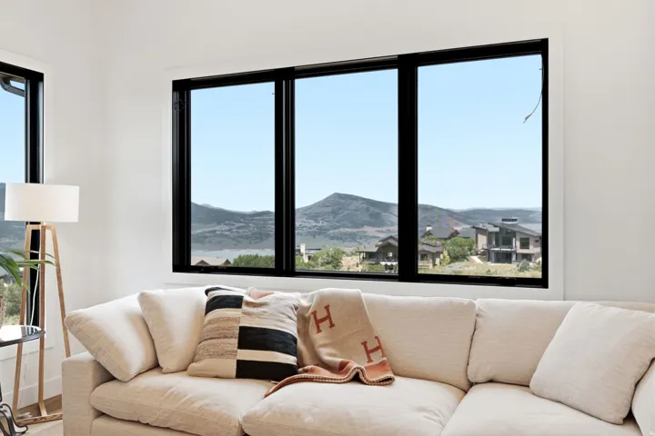 Expansive window wall with black trim framing mountain scenery
