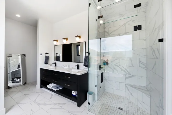 Dual vanity with black cabinetry, white countertops, and matte black fixtures