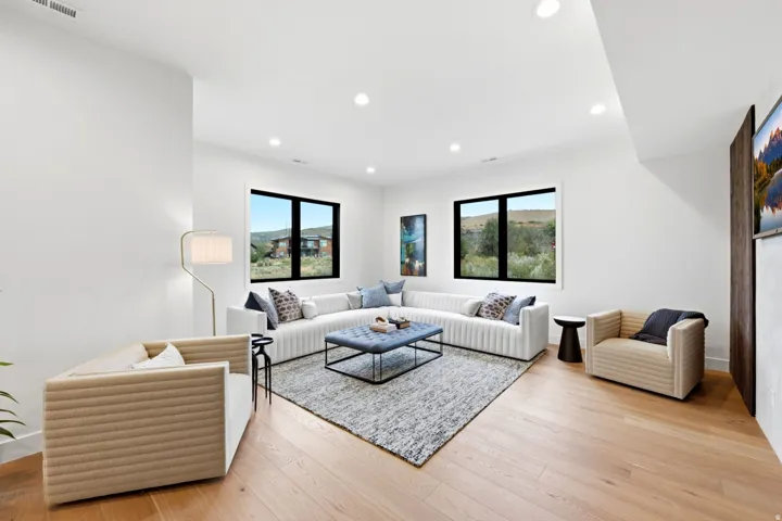 Recessed lighting, wood-finish flooring, and multiple black-framed windows