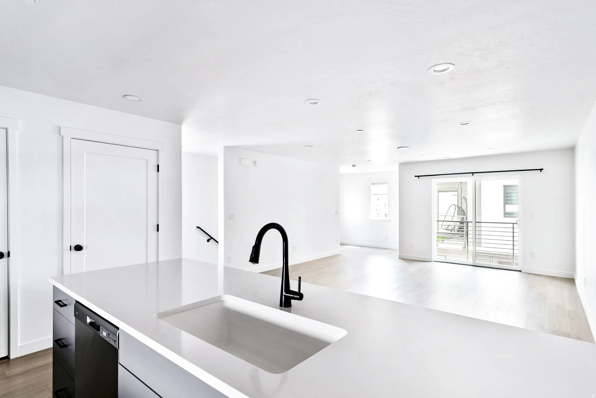 Kitchen island with integrated sink, matte black faucet, and dishwasher