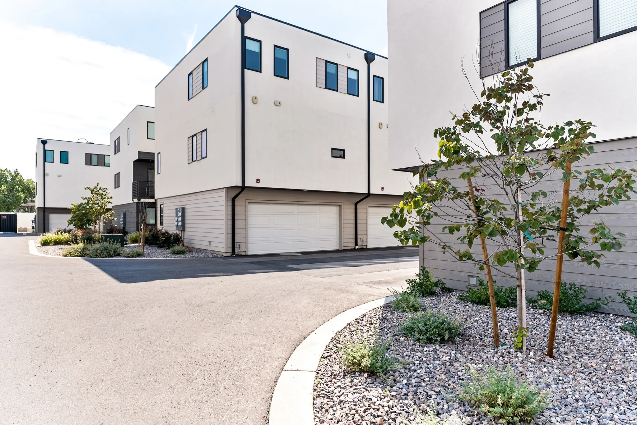 Modern multi-level exterior with crisp white stucco and horizontal siding accents