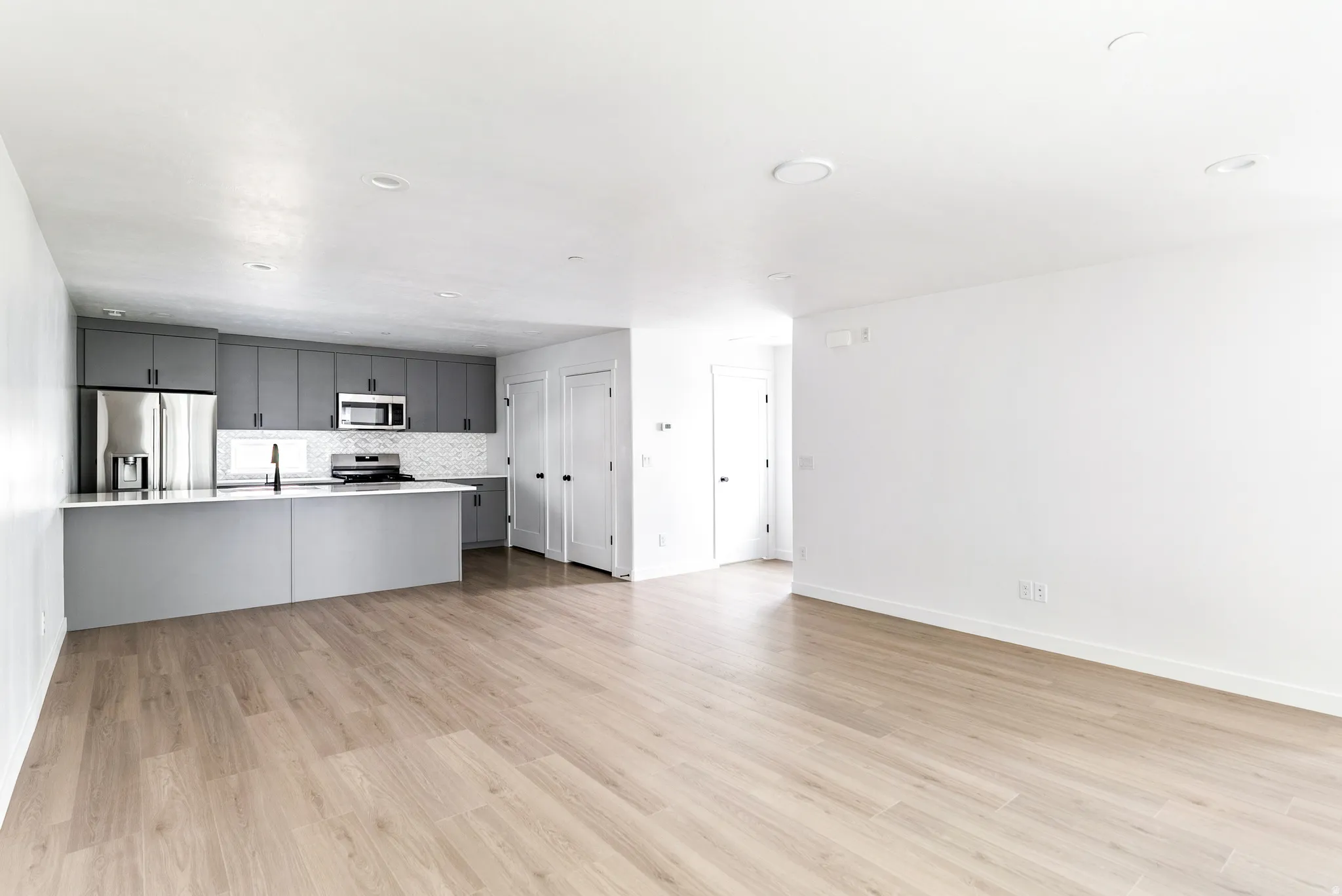 Open-concept living area featuring light wood-finish flooring