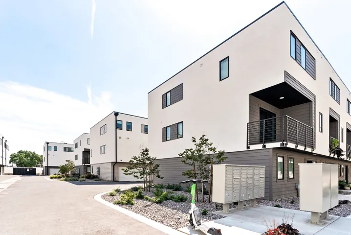 Modern architectural style, multi-level residences, balconies with metal railings, integrated garages, and clean exterior finishes