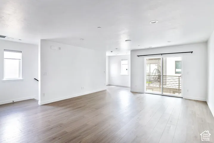 Spacious interior featuring wood-finish flooring, recessed lighting, and white walls