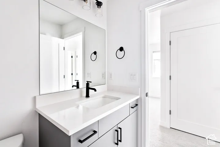 Vanity with a white countertop, undermount sink, and matte black faucet