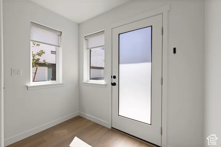 White walls, wood-finish flooring, and white trim throughout