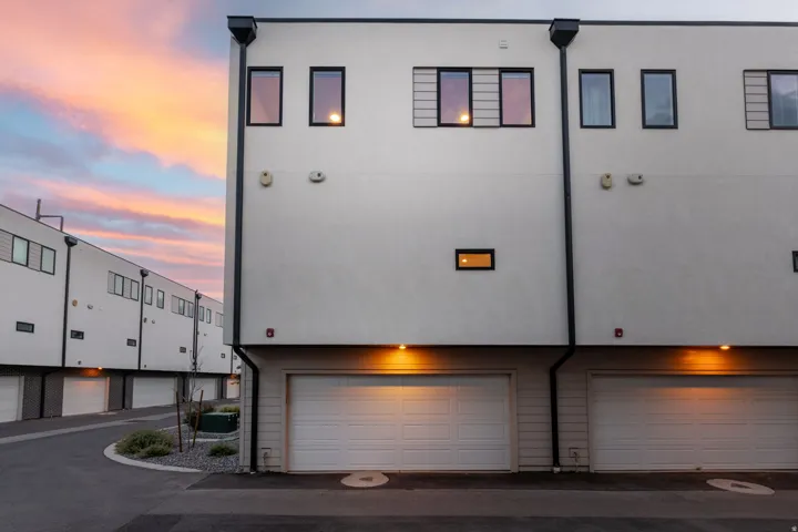 Modern multi-story exterior with white stucco finish and black-framed windows