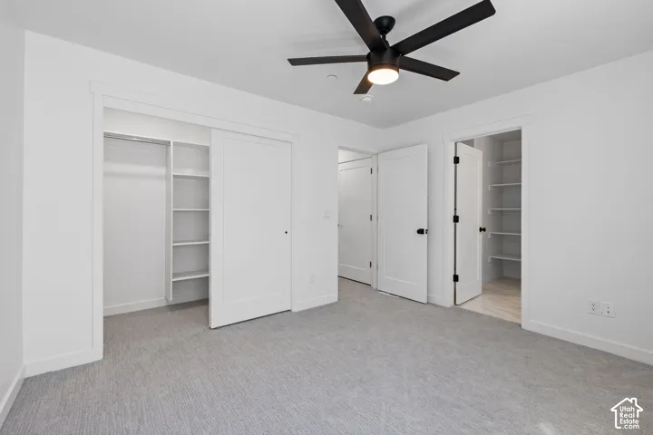 Recessed lighting, black ceiling fan, light gray carpeting, built-in closet shelving, and white interior doors