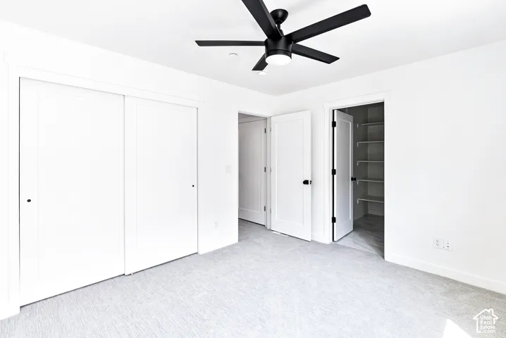 Recessed lighting, light-colored carpeting, white interior doors, and a black ceiling fan