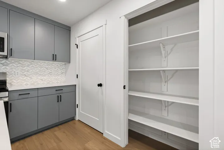 Modern cabinetry with matte gray finishes, white countertops, and a patterned tile backsplash