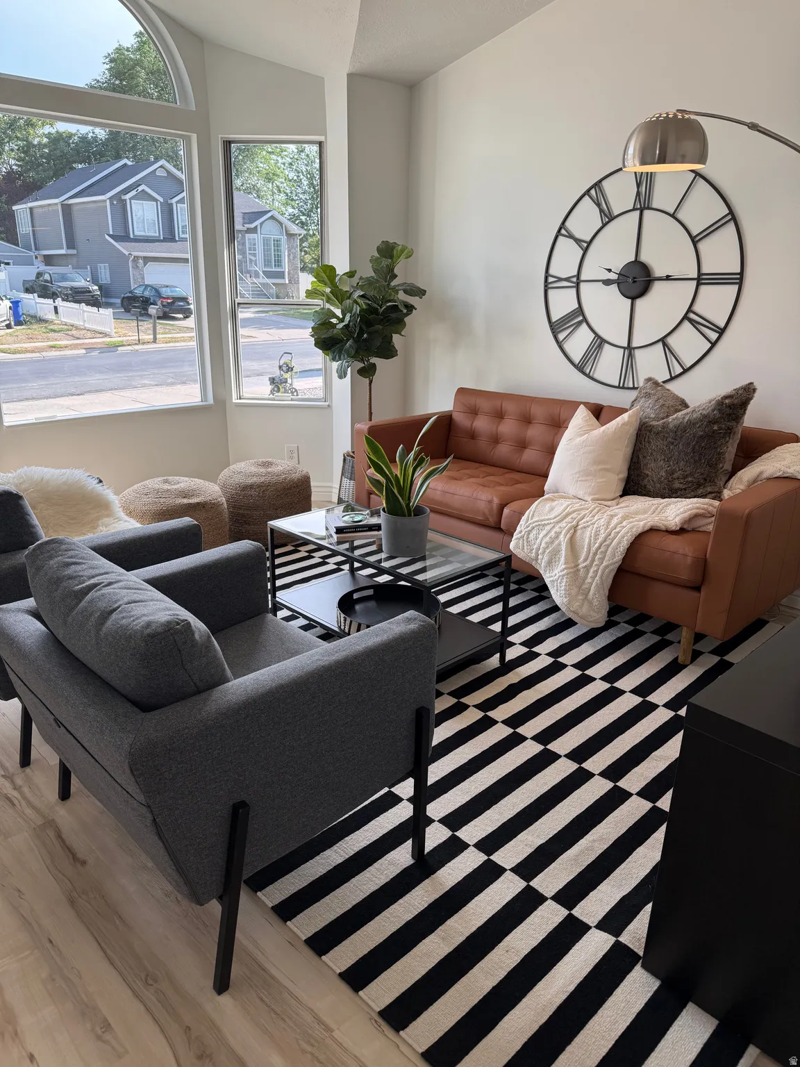 Vaulted ceiling, arched window, wood-finish flooring, glass-top coffee table, recessed lighting