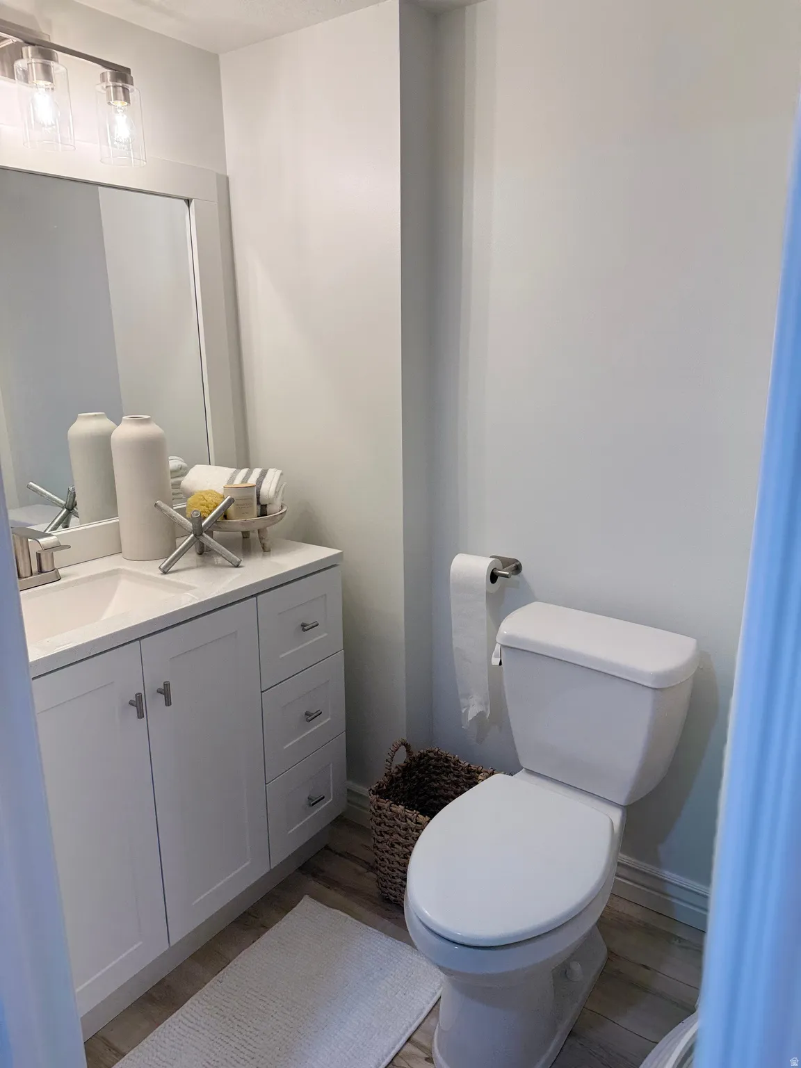 Bath for the 4th and 5th bedrooms on the mid and lower levels.White shaker-style vanity with a single basin sink, brushed nickel faucet, and a large framed mirror