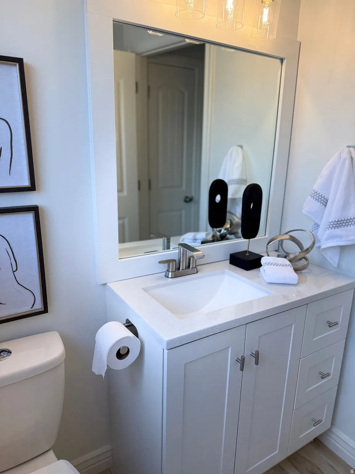 Modern 2nd upper level bathroom featuring a white vanity with integrated sink, quartz-finish countertop, and LVP flooring