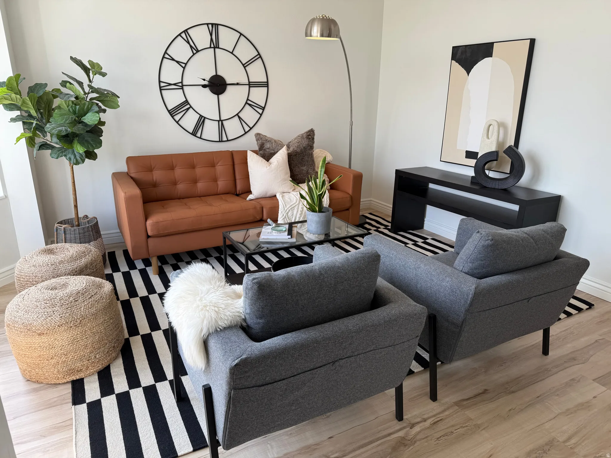 Light wood-finish flooring, white wall finishes, and a contemporary wall clock