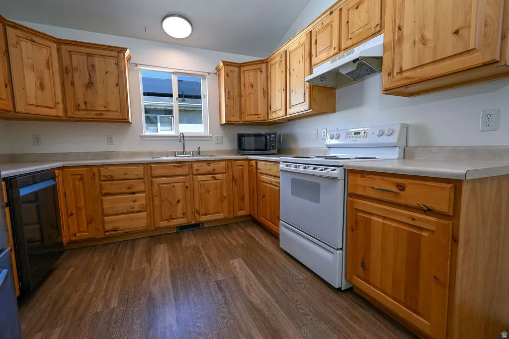 Kitchen featuring wood-finish cabinetry, light-toned countertops, and wood-finish flooring