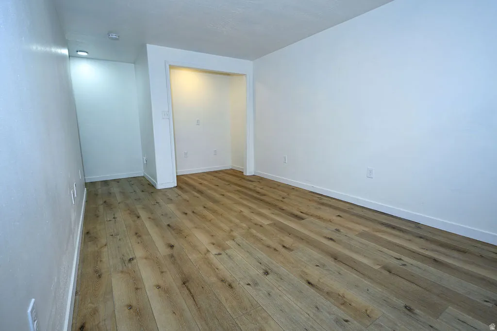 Wood-finish flooring throughout, recessed lighting, and a built-in alcove feature