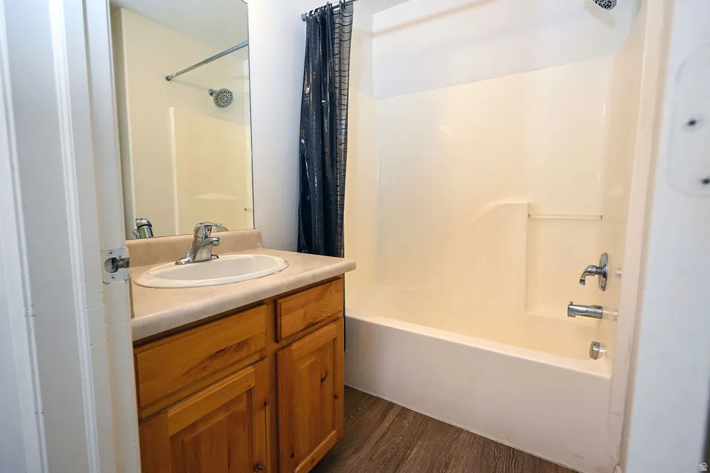 Single vanity with an integrated sink, wood-finish cabinetry, and a chrome faucet